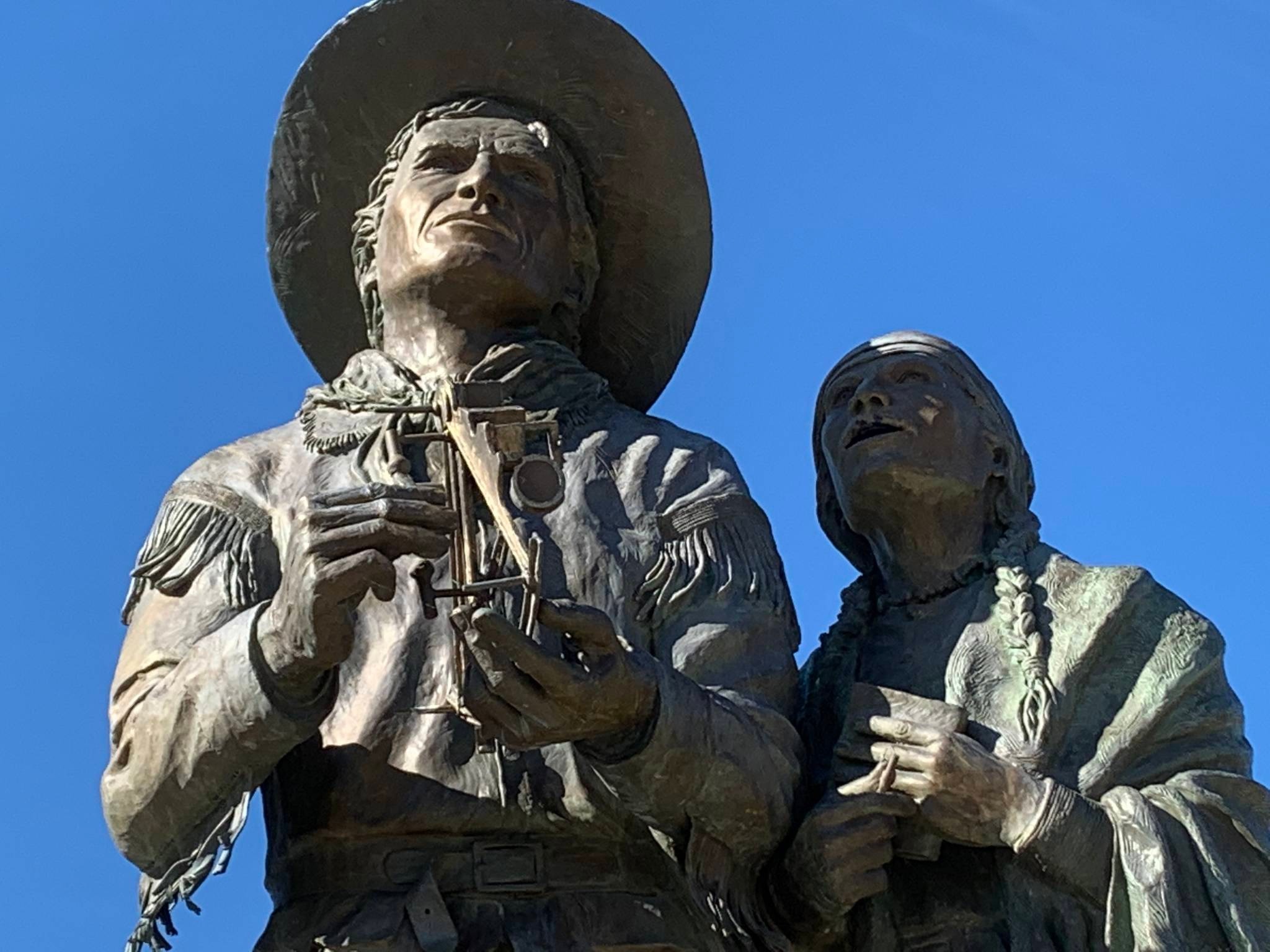 Sculpture depicting David Thompson and Charlotte Small against a blue sky.